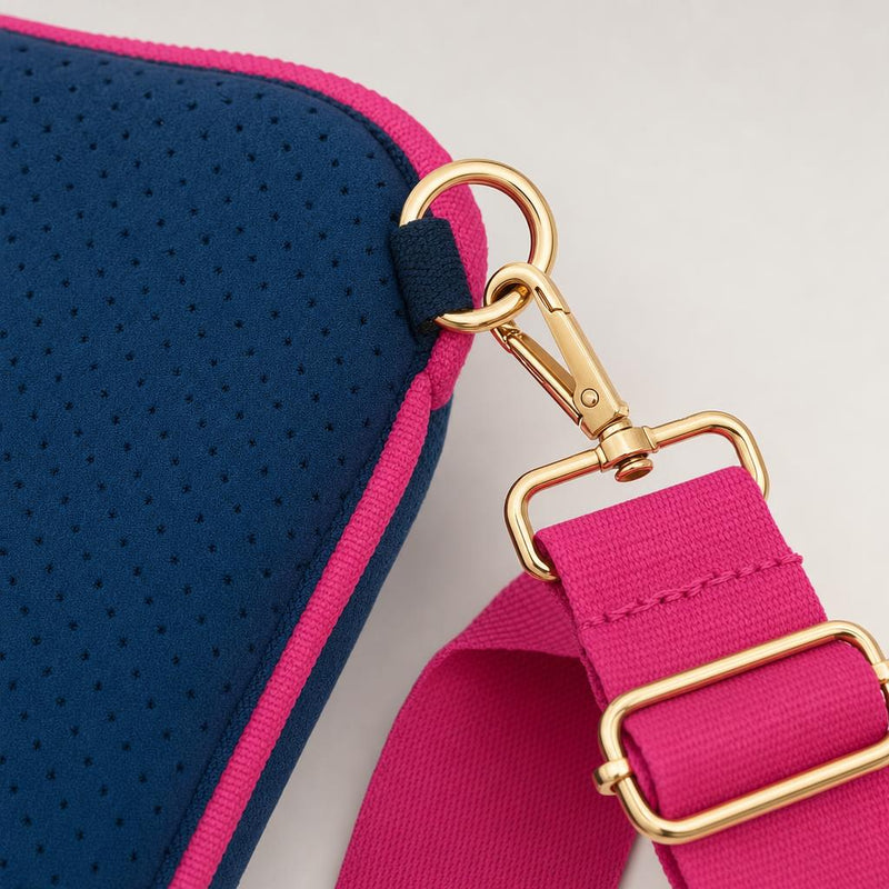 The gold carabiners on the strap, clipped to the side rings.