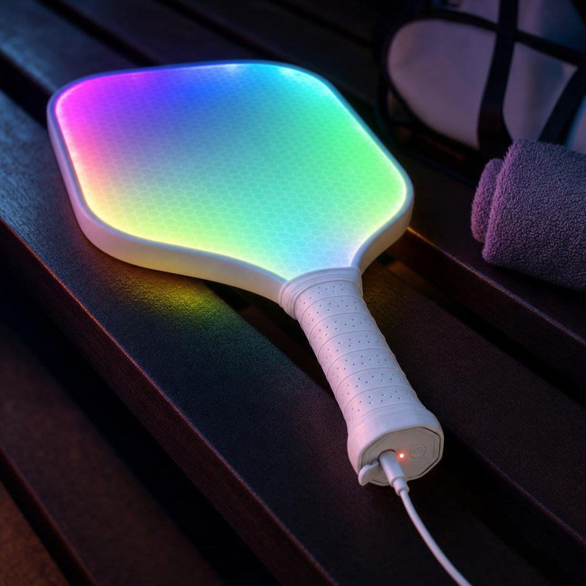 Pala ACE cargándose: el cable USB-C entra en el tapón octogonal del extremo del mango, con la luz roja de carga