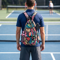 Player seen from behind on court with the floral RALLY backpack on their back and two paddles in the sleeve